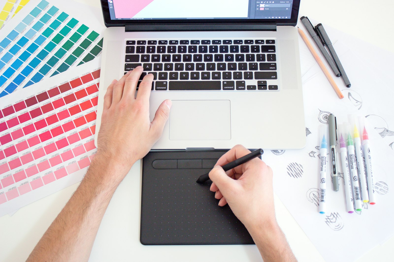 Graphic designer working with colour charts and a laptop
