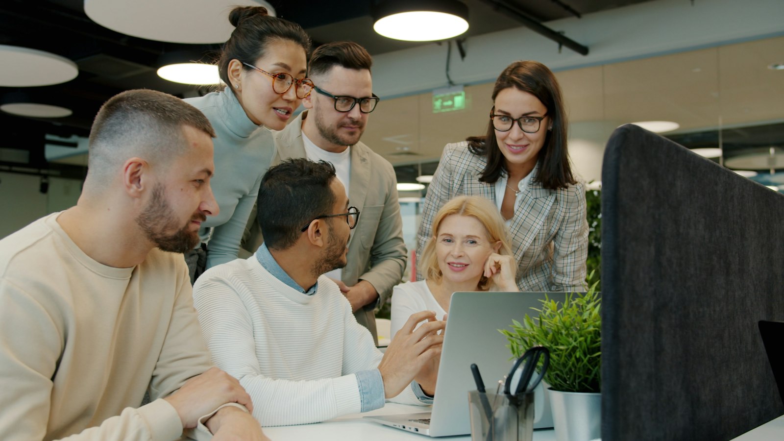 Creative team collaborating around a laptop